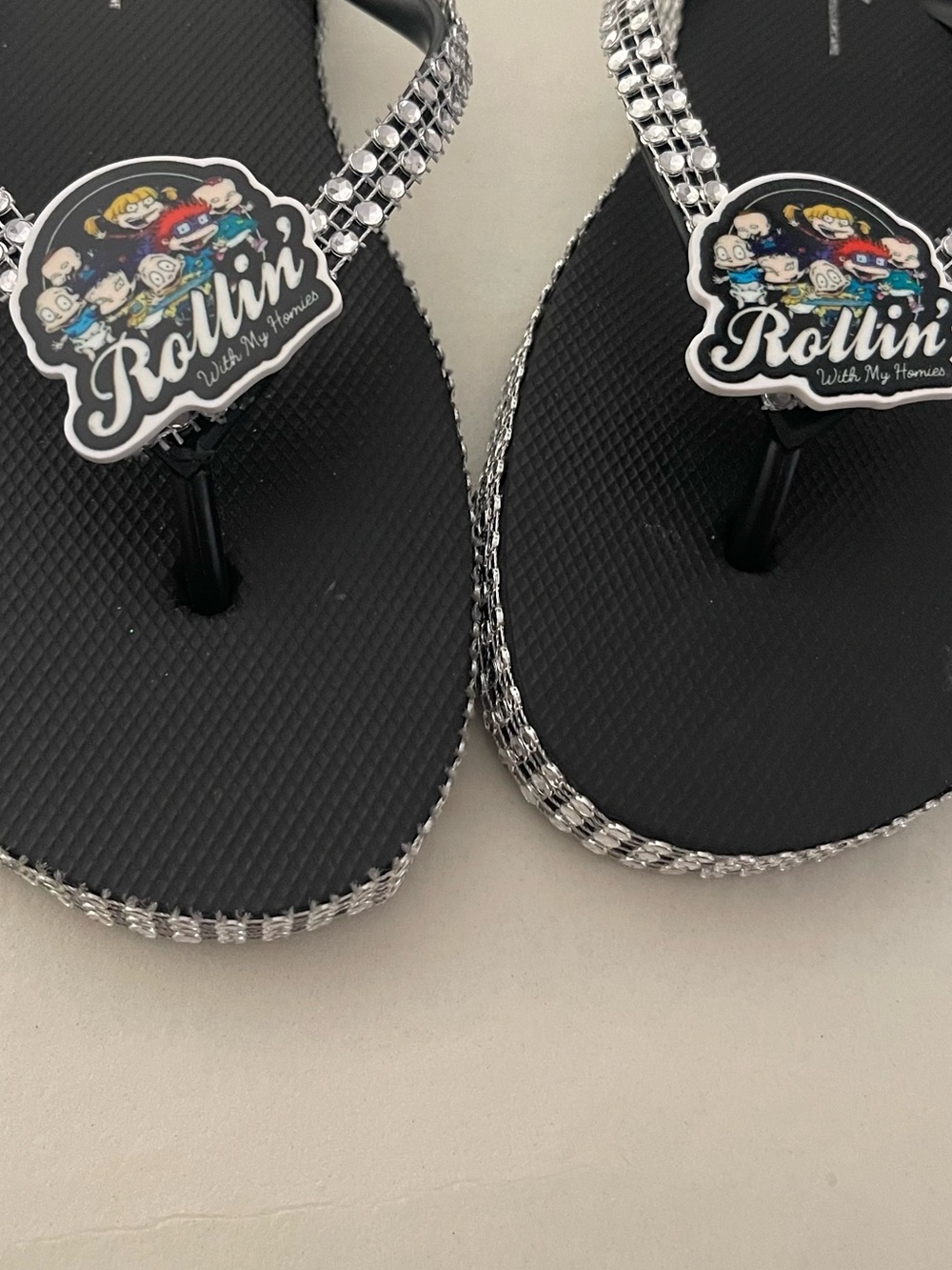 Black Flip Flop Sandals with Silver Trim and Character Badge